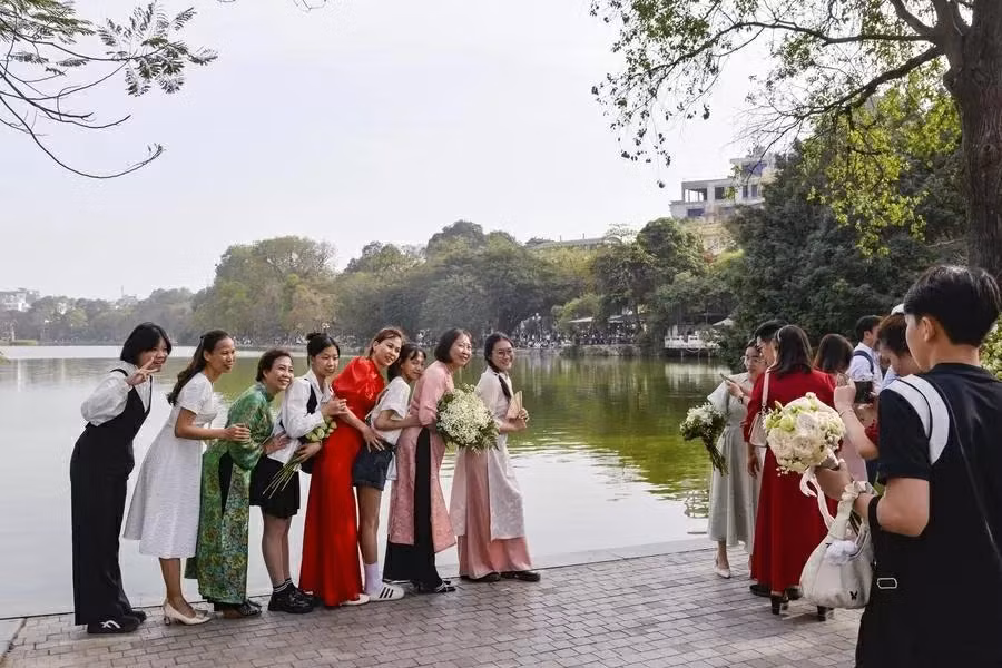 Des touristes posent pour des photos sur les rives du lac Hoan Kiem. Photo : Xinhua. Des touristes posent pour des photos sur les rives du lac Hoan Kiem. Photo : Xinhua.