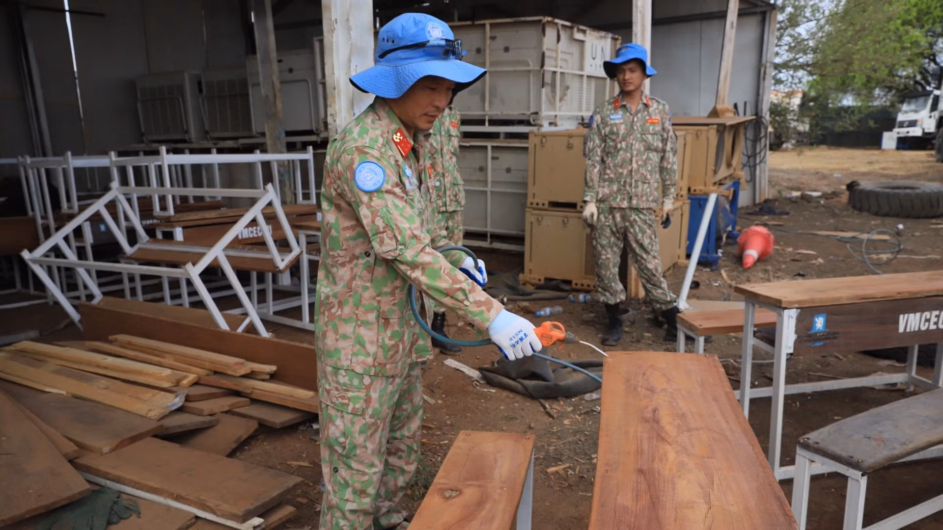 Le personnel de la 2e sous-unité de construction du génie militaire n° 3 fabrique des tables-bancs à partir de matériaux récupérés.
