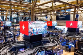 Les drapeaux vietnamiens et les messages félicitant le Vietnam pour son passage du statut de marché frontière à celui de marché émergent apparaissent sur de grands écrans à la Bourse de New York, aux États-Unis. Photo : VGP.
