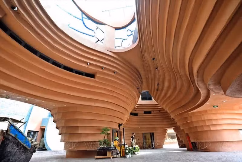 Le Musée de la poterie de Bat Tràng ne passe pas inaperçu dans le quartier avec son architecture fantaisiste, sa façade de couleur marron qui rappelle l’argile, et ses lignes courbes qui donnent l’impression de voir des vases encastrés les uns contre les autres. Photo : VNP.