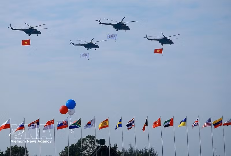 Un vol de formation d’hélicoptères arborant le drapeau national vietnamien effectue une démonstration aérienne lors de la cérémonie d’ouverture de l’Exposition internationale de défense du Vietnam 2024. Photo : VNA