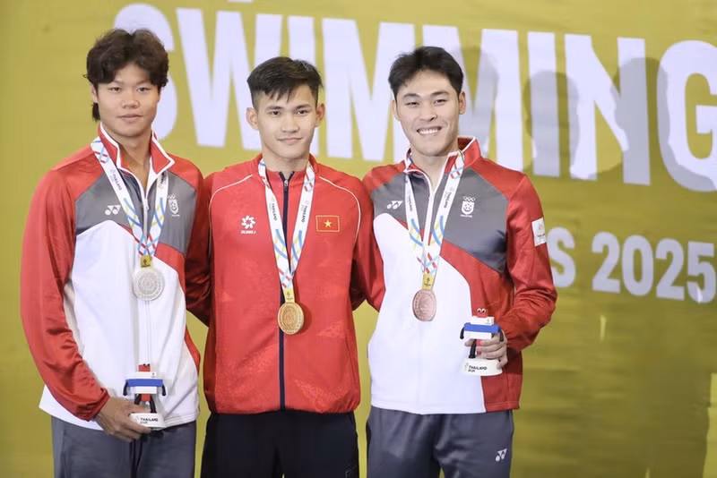Le nageur Pham Thanh Bao (au milieu) remporte la médaille d'or du 200 m brasse messieurs. Photo : VNA