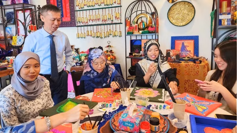 Des étudiants de l'UBD décorent des motifs traditionnels vietnamiens et brunéiens lors d'un échange culturel. Photo : NDEL.