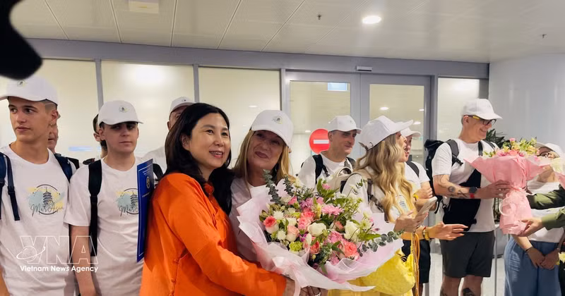 La directrice du Département du tourisme de Hanoï, Dang Huong Giang, offre des fleurs pour féliciter le 5 millionième visiteur international et une délégation espagnole à l'aéroport de Noi Bai, le 7 juillet 2026 après-midi. Photo : VNA 