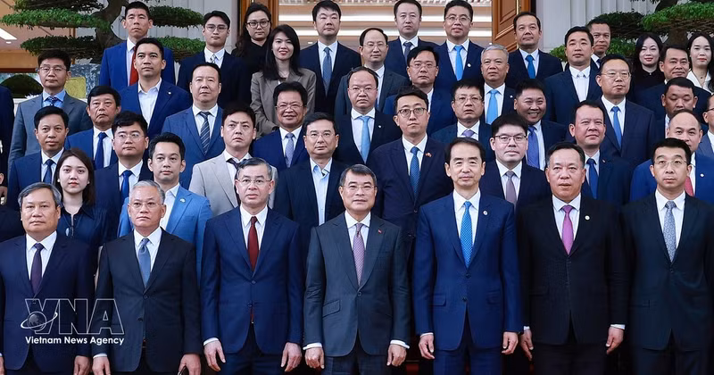 Le Premier ministre Le Minh Hung (au centre de la première ligne) et des représentants d' entreprises chinoises implantées au Vietnam. Photo : VNA. 