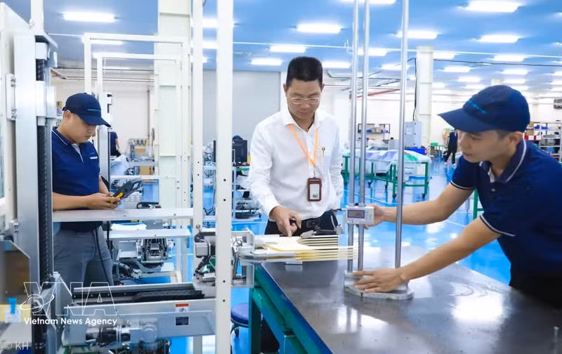 Bui Anh Long, directeur exécutif de la société à responsabilité limitée TAZMO, inspecte un robot de transfert de wafers destiné à l’industrie des semi-conducteurs avant son expédition. Photo : VNA.