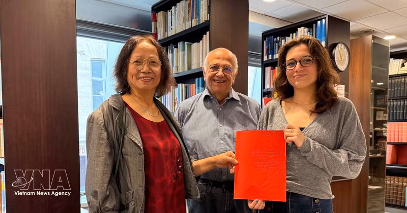 La chercheuse culturelle Tran Thu Dung (à gauche), Yonnel Ghernaouti, membre du conseil d'administration de l'Institut maçonnique de France, et Emma Lallemand, bibliothécaire au GODF, posent avec des documents d'archives sur Nguyên Ai Quôc. Photo : VNA. 