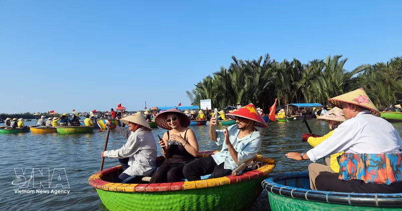Des touristes internationaux découvrent le village de cocotiers de Cam Thanh, classé parmi les 50 plus beaux villages du monde en 2025. Photo : VNA. 