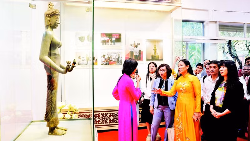Des visiteurs admirent l’originale de la statue du Bodhisattva Tara, classée trésor national, dans l’espace d’exposition « Trésors nationaux – Un patrimoine au cœur de Da Nang ».