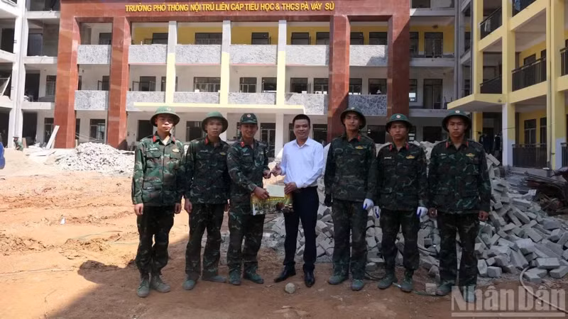 Duong Viet Hung, président du Comité populaire de la commune de Pa Vay Su remet des présents aux militaires mobilisés sur le chantier et les encourage.