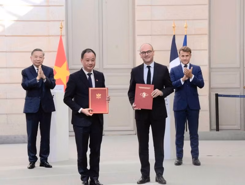 Tran Hong Thai, président de l’Académie vietnamienne des sciences et des technologies, échange avec Sébastien Martin, ministre délégué auprès du ministre français de l’Économie, des Finances et de la Souveraineté industrielle, énergétique et numérique, une lettre d’intention visant à promouvoir le projet VNREDSat-2, en présence du secrétaire général du PCV et président vietnamien To Lam et du président français Emmanuel Macron.