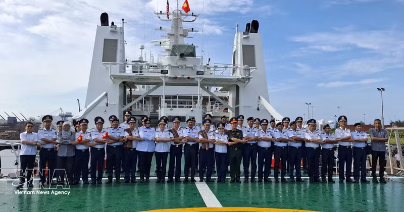 Des représentants des Garde-côtes vietnamiens et de l’Agence malaisienne de contrôle maritime (MMEA) de Pahang prennent une photo souvenir selon la tradition de l’ASEAN à bord du CSB 8005. Photo : VNA 
