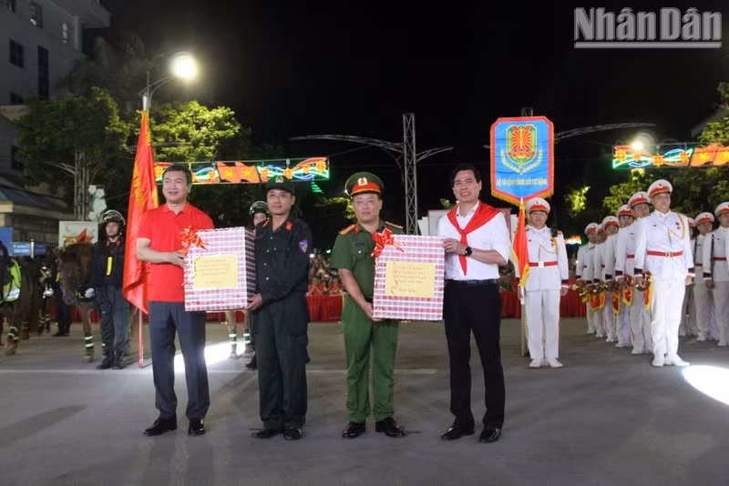 Les dirigeants provinciaux remettent des présents aux représentants de la fanfare et de l’unité de police montée. Photo : Quoc Dat.