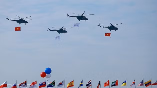 Un vol de formation d’hélicoptères arborant le drapeau national vietnamien effectue une démonstration aérienne lors de la cérémonie d’ouverture de l’Exposition internationale de défense du Vietnam 2024. Photo : VNA