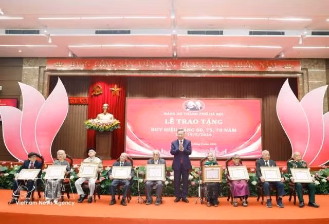 Le secrétaire général du Parti et président To Lam remet des insignes commémoratifs de 80 ans d'adhésion au Parti à 19 membres. Photo : VNA. 