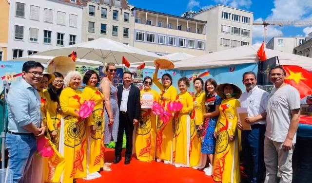 Des amis internationaux prennent une photo souvenir au stand du Vietnam. Photo : Revue Huong Viet.