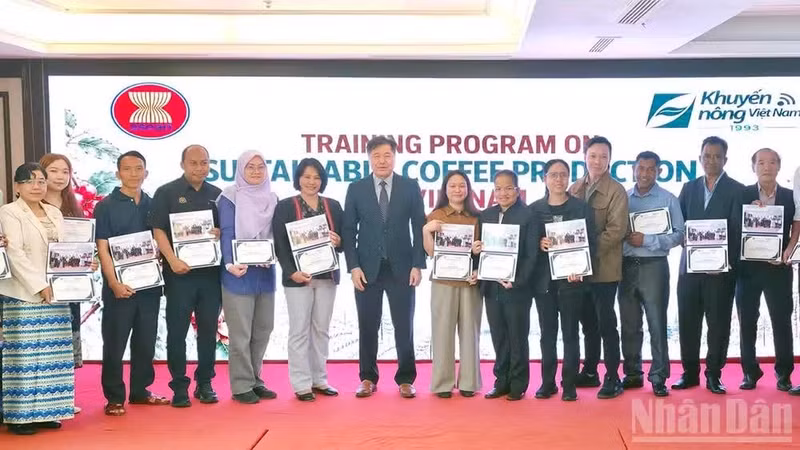 Le directeur du Centre national de vulgarisation agricole, Le Quoc Thanh, remet des certificats et pose pour une photo souvenir avec les participants à la formation. (Photo : BAO VAN)