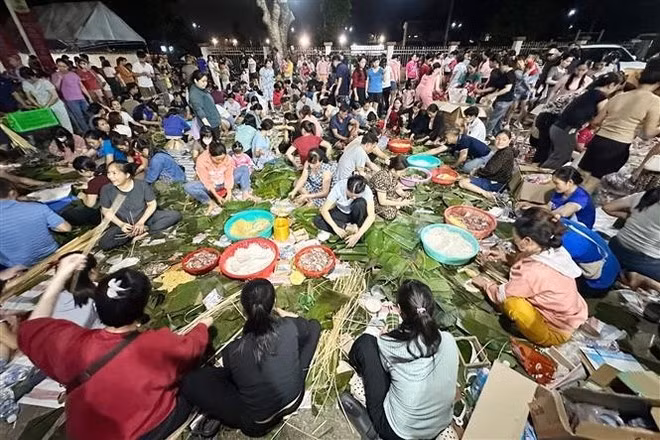 Des centaines de personnes préparent des gâteaux de riz pendant la nuit dans le quartier de Trang Dai, province de Dong Nai, pour envoyer aux sinistrés des inondations. Photo : VNA