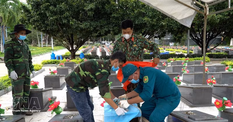 Prélèvement d'échantillons de restes de soldats au cimetière des martyrs de Duc Co. Photo: VNA 