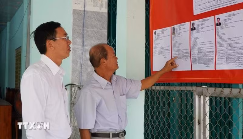 Des électeurs consultent les brèves biographies des candidats au Conseil populaire de la commune de Tan Hong, province de Dong Thap, mandat 2026-2031. Photo : VNA.
