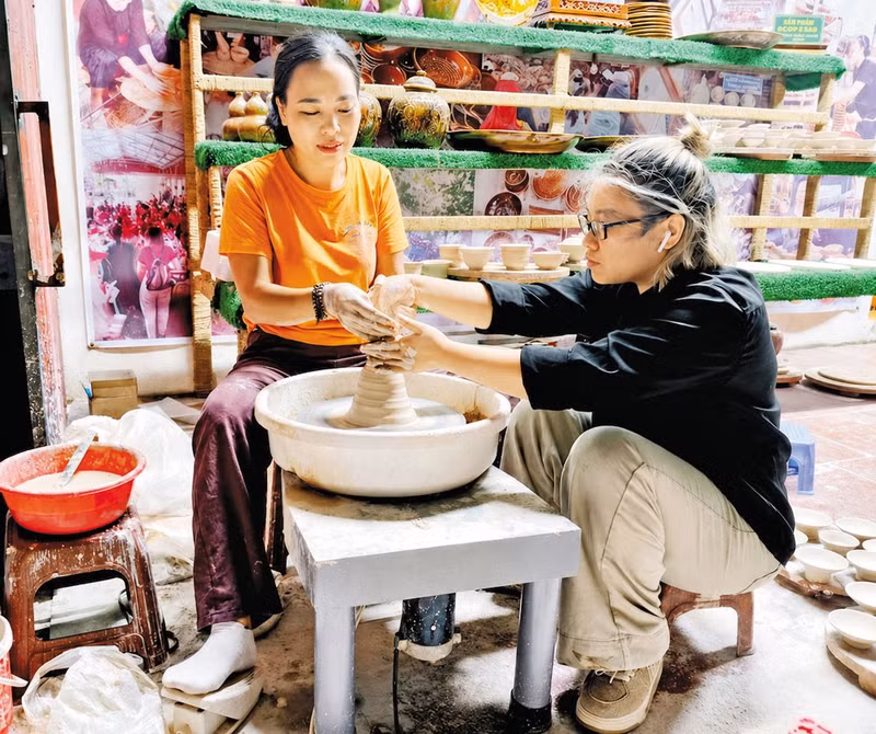 Dang Thi Tam (à gauche) explique les techniques de fabrication de la poterie de Phu Lang. Photo: baobacninhtv.vn