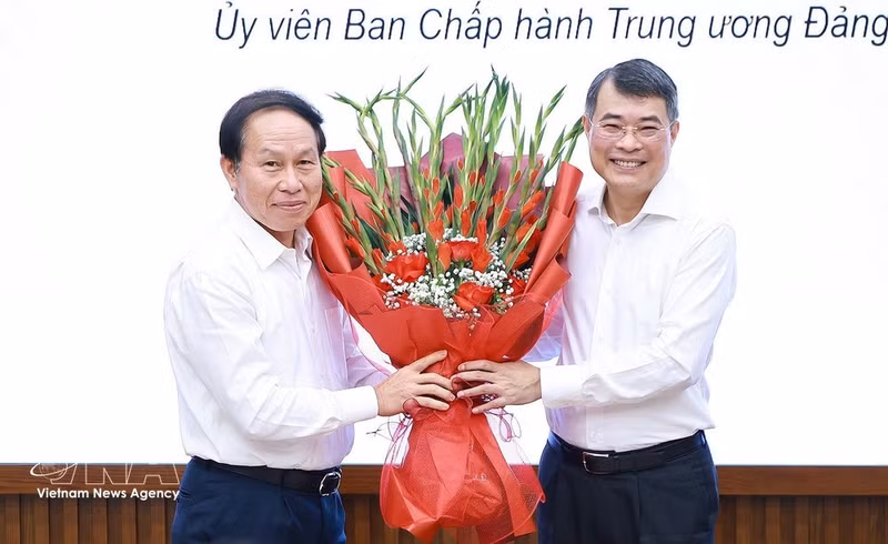 Le Tien Chau, membre du Comité central du Parti et vice-Premier ministre (gauche), représentant les participants à la formation, offre un bouquet de fleurs au Premier ministre Le Minh Hung. Photo: VNA