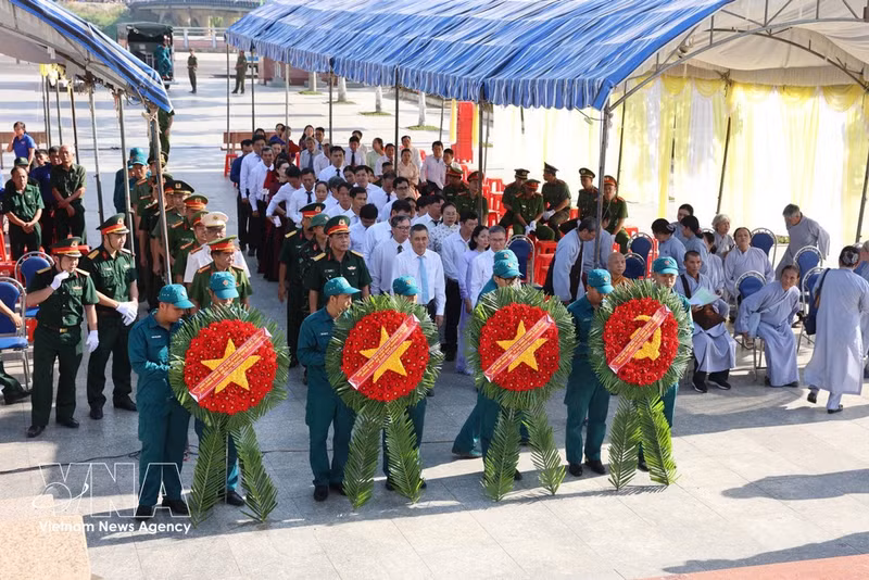 Des cadres et des soldats des forces armées rendent hommage aux héros et martyrs en déposant respectueusement des gerbes de fleurs. Photo : VNA
