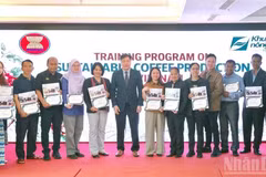Le directeur du Centre national de vulgarisation agricole, Le Quoc Thanh, remet des certificats et pose pour une photo souvenir avec les participants à la formation. (Photo : BAO VAN)