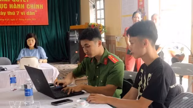 Un policier du quartier de Ly Thuong Kiet, dans la province de Ninh Binh, explique aux habitants comment utiliser l’application VNeID sur leur smartphone. Photo : VNA.