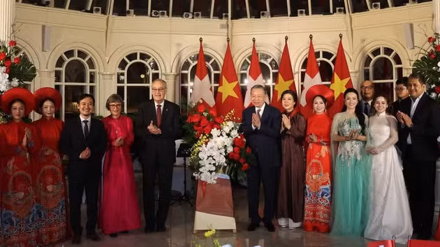 Le secrétaire général du Parti et président de la République, To Lam, et son épouse, Ngô Phuong Ly, ainsi que le président suisse, Guy Parmelin, et son épouse, Caroline Parmelin, offrent des fleurs aux artistes. Photo : VNA.
