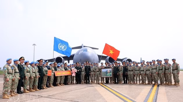 Le général de corps d’armée Le Quang Dao, chef d’état-major général adjoint de l’Armée populaire du Vietnam, et des responsables des unités posent pour une photo avec les cadres et militaires avant leur départ pour une mission internationale. Photo: VNA