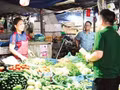 Au marché de Dong Xa (dans la capitale vietnamienne Hanoi), des employés de VPBank accompagnent des commerçants dans l’ouverture d’un compte dédié à leur activité directement sur leur étal. (Photo : MAI HA)