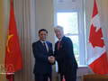 Le ministre de l’Industrie et du Commerce, Le Manh Hung (à gauche), et le ministre canadien de l’Énergie et des Ressources naturelles, Tim Hodgson, se serrent la main avant leur entretien à Ottawa. Photo : VNA.