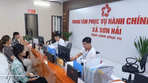 Des habitants effectuent des procédures administratives au centre des services administratifs publics de la commune de Son Hai (province de Bac Ninh). Photo : VNA.