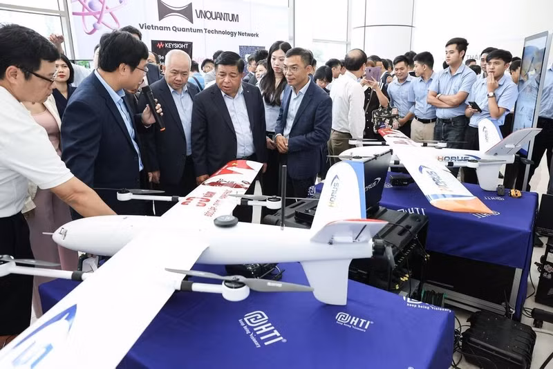 Des visiteurs dans un stand d'exposition lors de la cérémonie de lancement de trois réseaux d’innovation dans les secteurs technologiques stratégiques : technologies quantiques, cybersécurité et aérospatiale/drones, en août 2025 à Hanoï. Photo : VNA