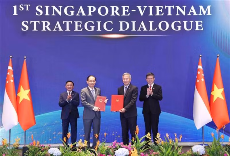 Le membre du Bureau politique et ministre des Affaires étrangères, Le Hoai Trung, et le ministre singapourien des Affaires étrangères, Vivian Balakrishnan, échangent la Déclaration commune sur la Stratégie de connectivité technologique Vietnam-Singapour. Photo : VNA.