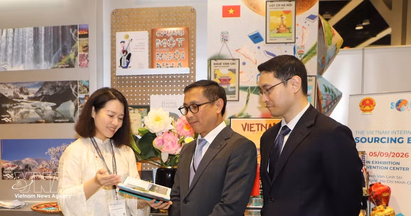 Des visiteurs étrangers découvrent des ouvrages sur la culture, le pays, le peuple et le tourisme du Vietnam lors de l'événement. Photo : VNA. 