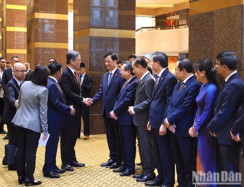 Chan Chun Sing, secrétaire général adjoint du PAP, ministre de la Défense et ministre chargé de la coordination des services publics de Singapour, rencontre des membres de la délégation vietnamienne. Photo : NDEL