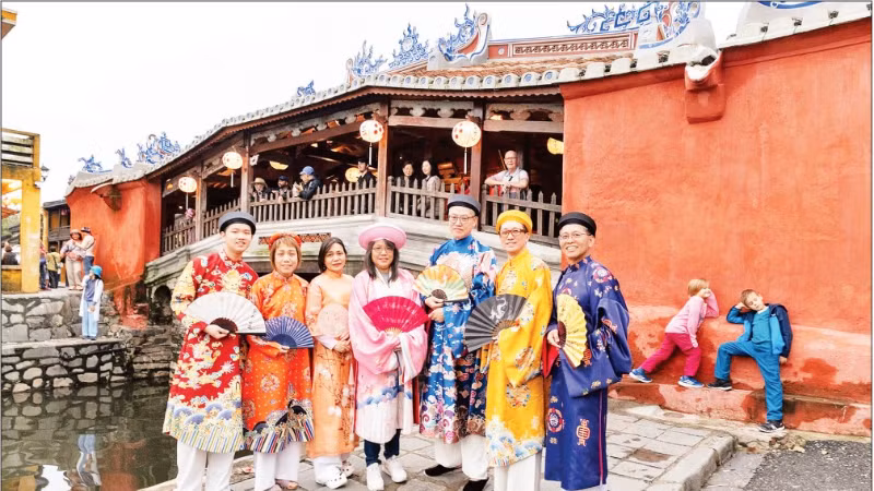 Des touristes portant des costumes traditionnels vietnamiens explorent la vieille ville de Hoi An (Da Nang). Photo : NDEL 