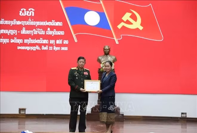 Remise du certificat de reconnaissance à un représentant du ministère lao de la Défense. Photo : VNA.