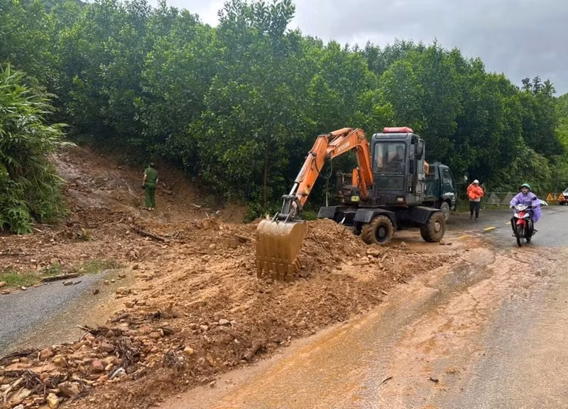 Les forces compétentes dégagent l’emplacement éboulé sur la route nationale 14G, commune de Hoa Vang, à Da Nang. Photo : VNA.