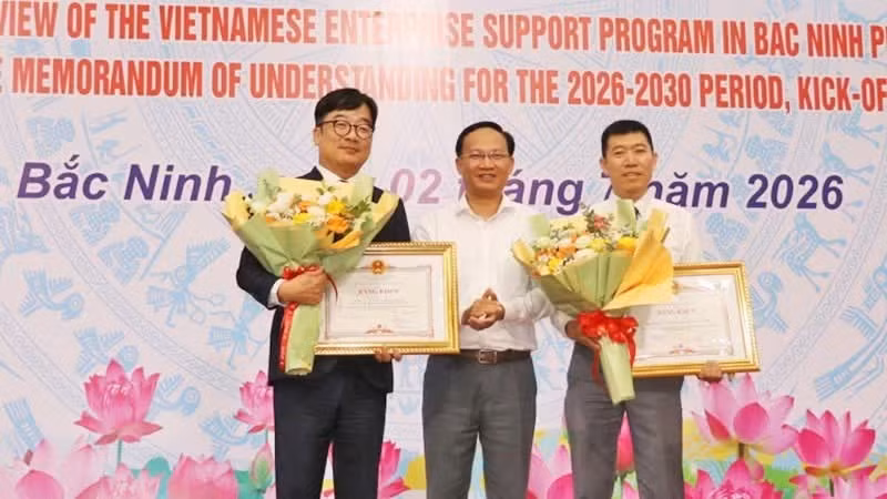 Le vice-président du Comité populaire de la province de Bac Ninh, Pham Van Thinh (au centre), remet des certificats de mérite à des collectifs et individus pour leurs contributions exceptionnelles à la mise en œuvre du Programme de soutien aux entreprises vietnamiennes dans la province de Bac Ninh au cours de la période 2020 – 2025. Photo : NDEL