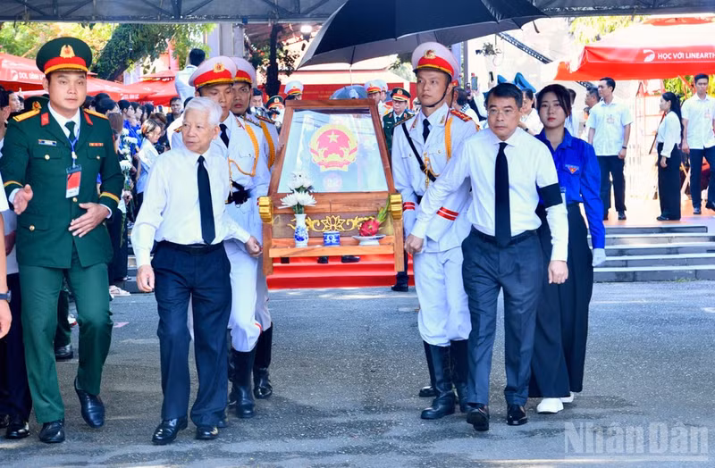 Le PM Le Minh Hung (à droite), l’ancien président Nguyen Minh Triet (à gauche) et d’autres délégués escortent les dépouilles des martyrs depuis le parc Le Thi Rieng. Photo : NDEL.