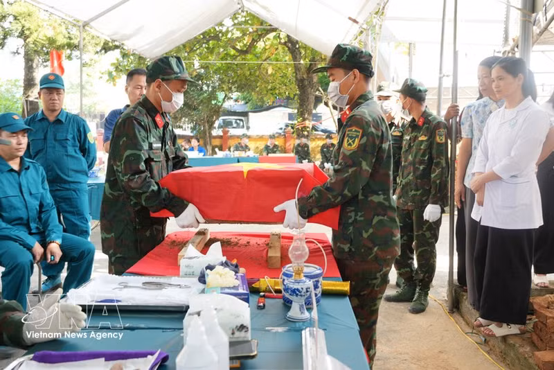 Des officiers et des soldats transportent les restes de martyrs jusqu'au poste de prélèvement d'échantillons du cimetière des martyrs de la commune de Binh Xuyen, dans la province de Phu Tho. Photo : VNA 
