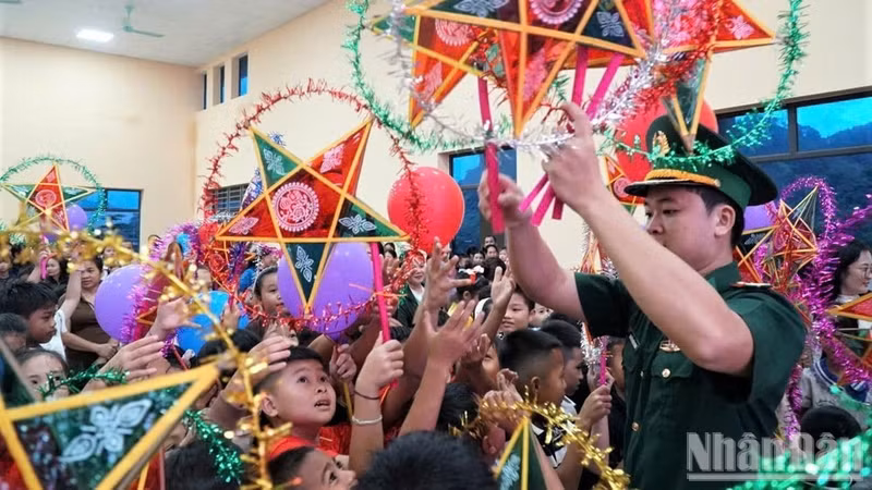 Les enfants reçoivent avec joie des lanternes traditionnelles en forme d’étoile à cinq branches. Photo : NDEL