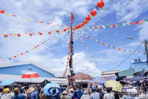 Des centaines d’habitants et de visiteurs encouragent avec ferveur les participants au mât de cocagne.