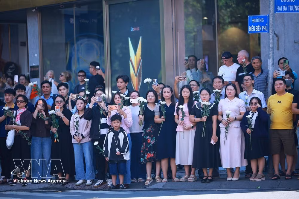 Des dizaines de milliers d’habitants se rassemblent le long des rues, des fleurs blanches à la main, pour rendre un dernier hommage aux soldats morts pour la Patrie. Photo : VNA.
