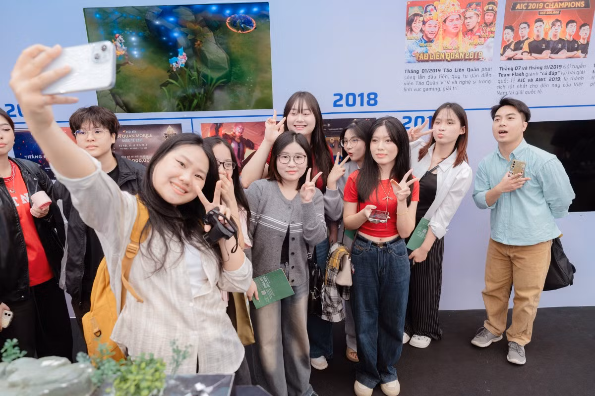 La Foire d’automne 2025 séduit également de nombreux jeunes visiteurs, notamment grâce aux stands des éditeurs de jeux vidéo et aux ateliers de création artisanale. Trinh Duc Hien (1er à droite), venu avec ses amis dès neuf heures du matin, a visité de nombreux stands et a confié avoir particulièrement apprécié celui du Théâtre national de marionnettes du Vietnam, qui lui a permis de découvrir la culture traditionnelle. Photo : vnexpress.net