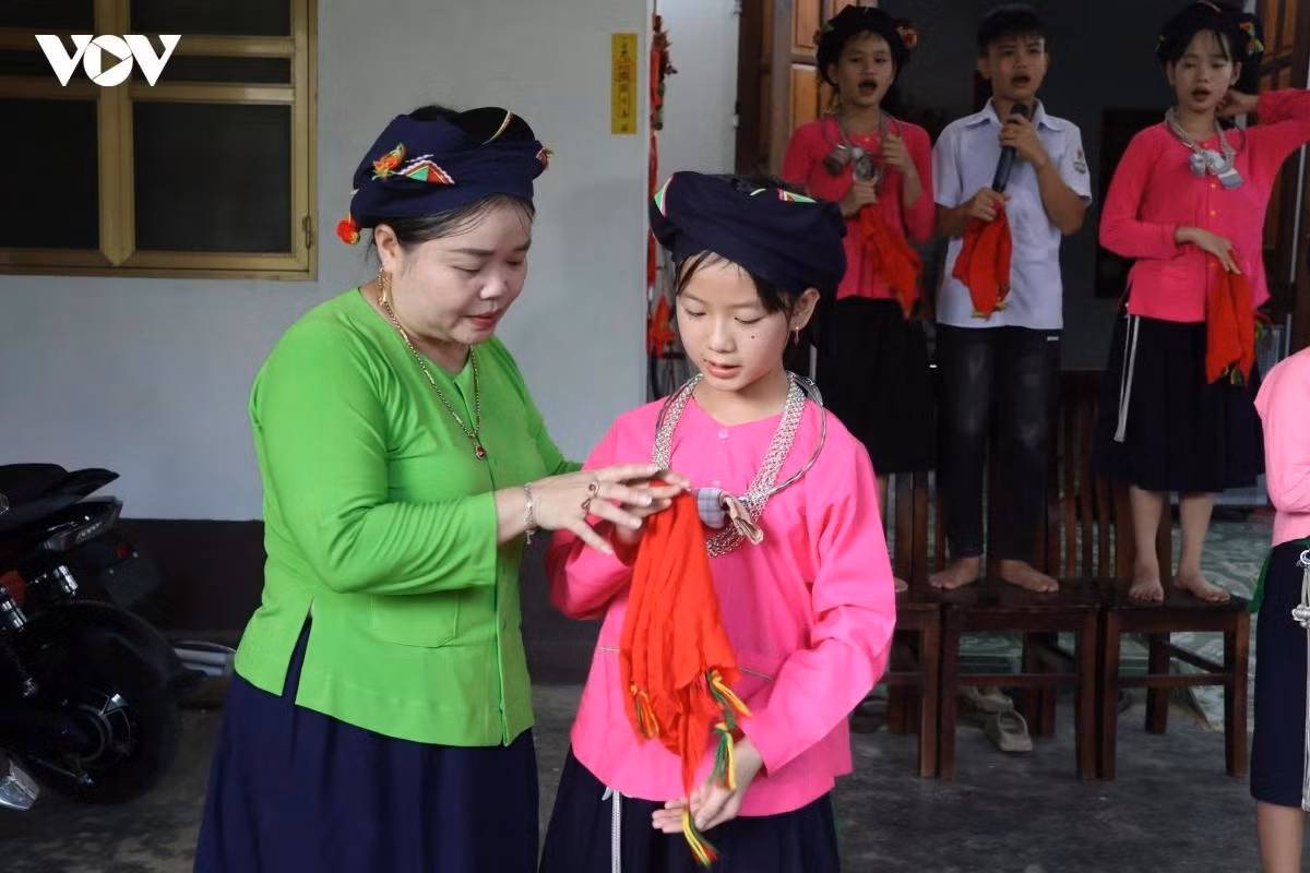 Mme Mai Thi Hong Chan a méticuleusement expliqué chaque mouvement et chaque technique des chants traditionnels de l'ethnie Tay aux enfants. Photo : VOV