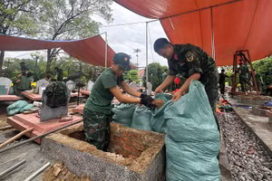 Des soldats du Commandement militaire provincial de Dien Bien mènent des fouilles au cimetière des martyrs de Doc Lap afin de recueillir les restes de soldats tombés au combat. Photo : NDEL